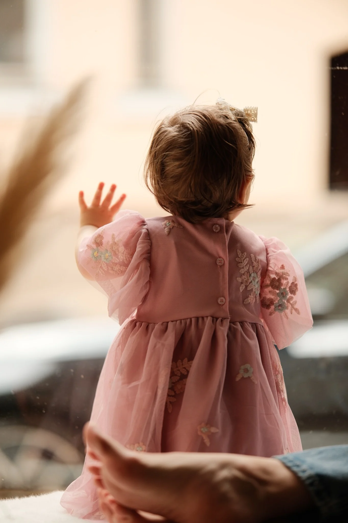 Kind steht am Fenster und schaut nach draußen