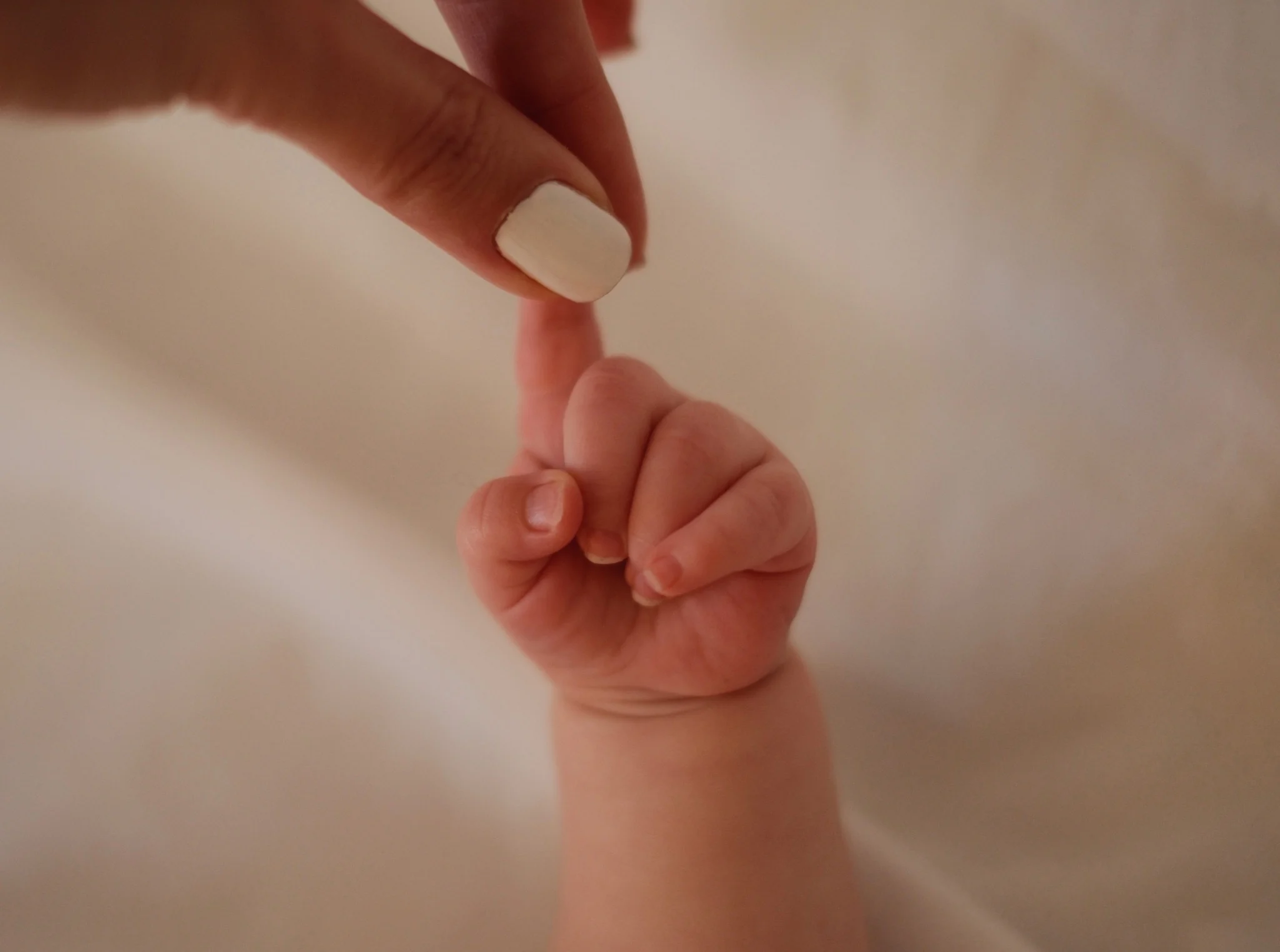 Babyhand hält den Finger der Mutter